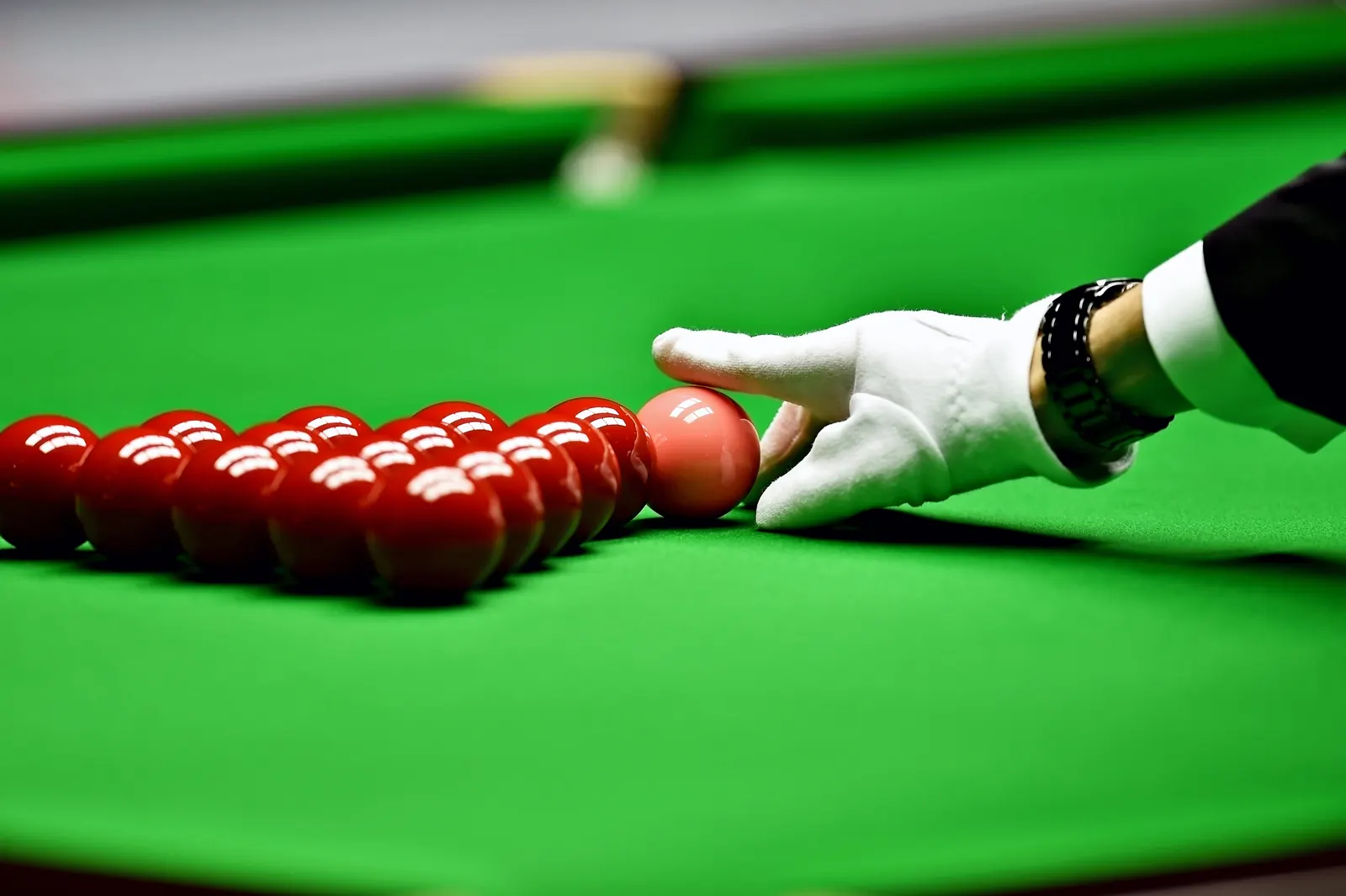 Hand legt die roten Kugeln ins Dreieck