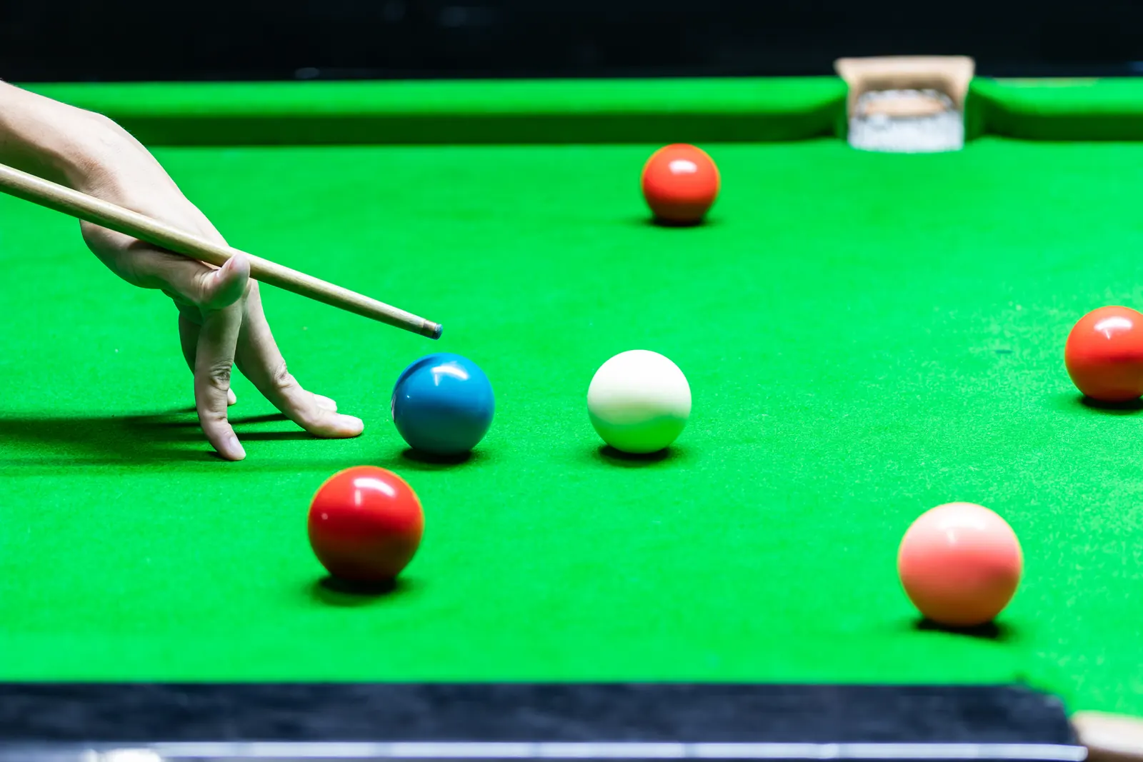Hand bildet die Brücke für das Queue auf dem Snookertisch