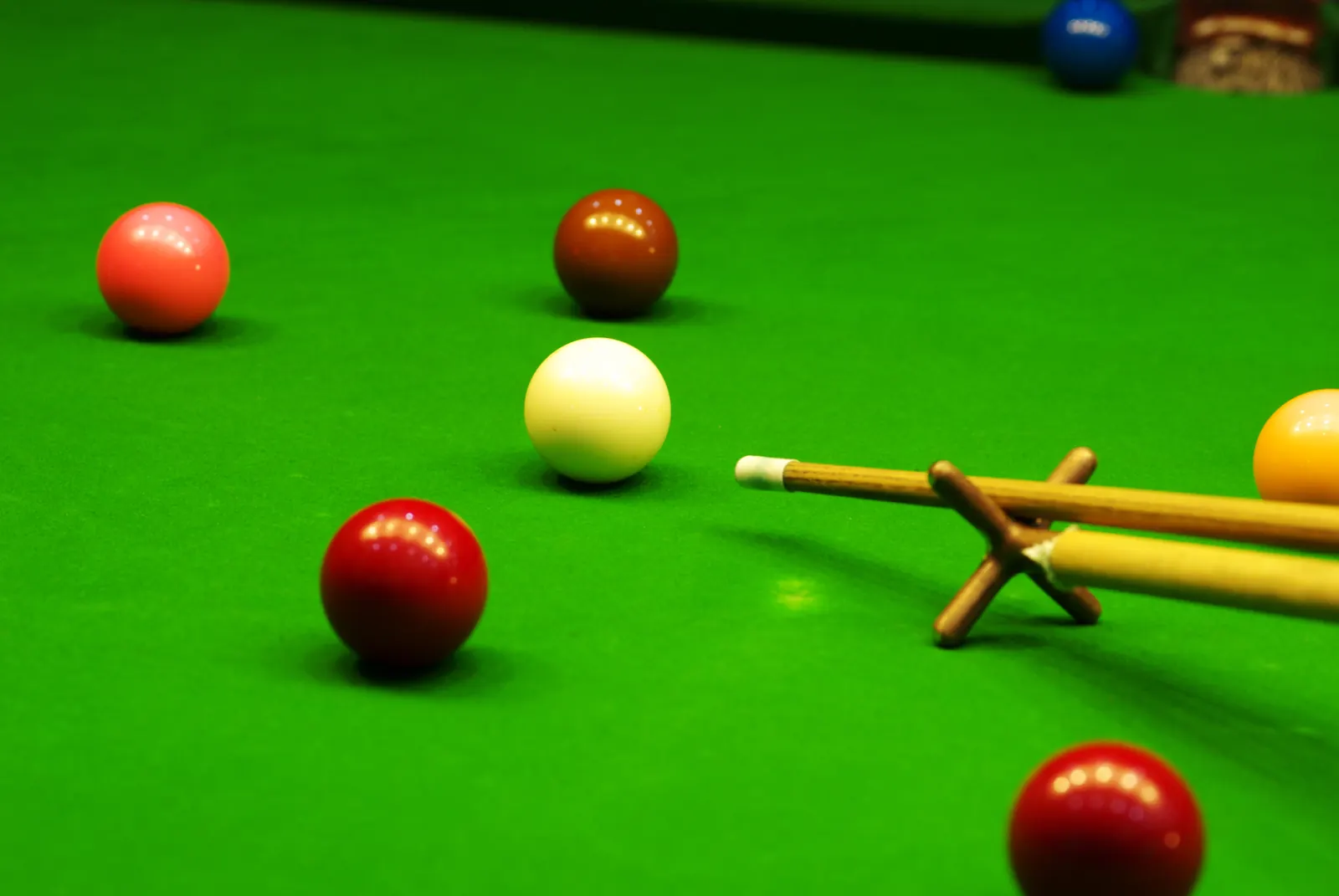 Snookerkugeln und Queue auf grünem Tuch