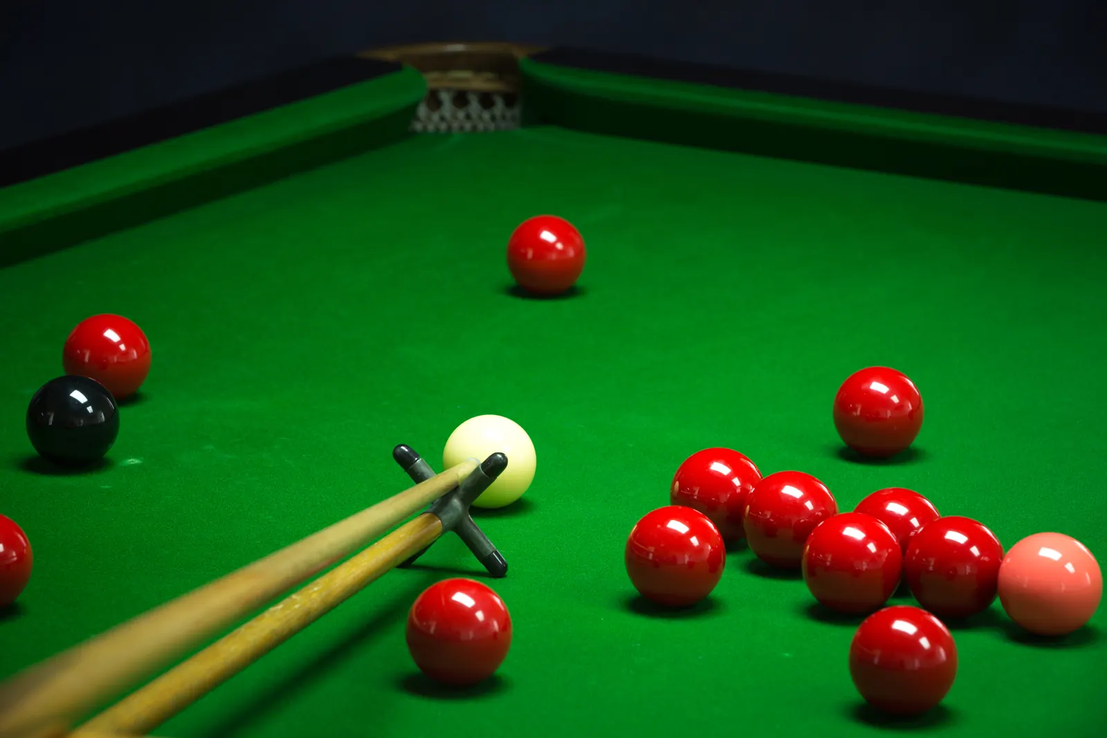 Rote Snookerkugeln und Queues auf dem Tisch