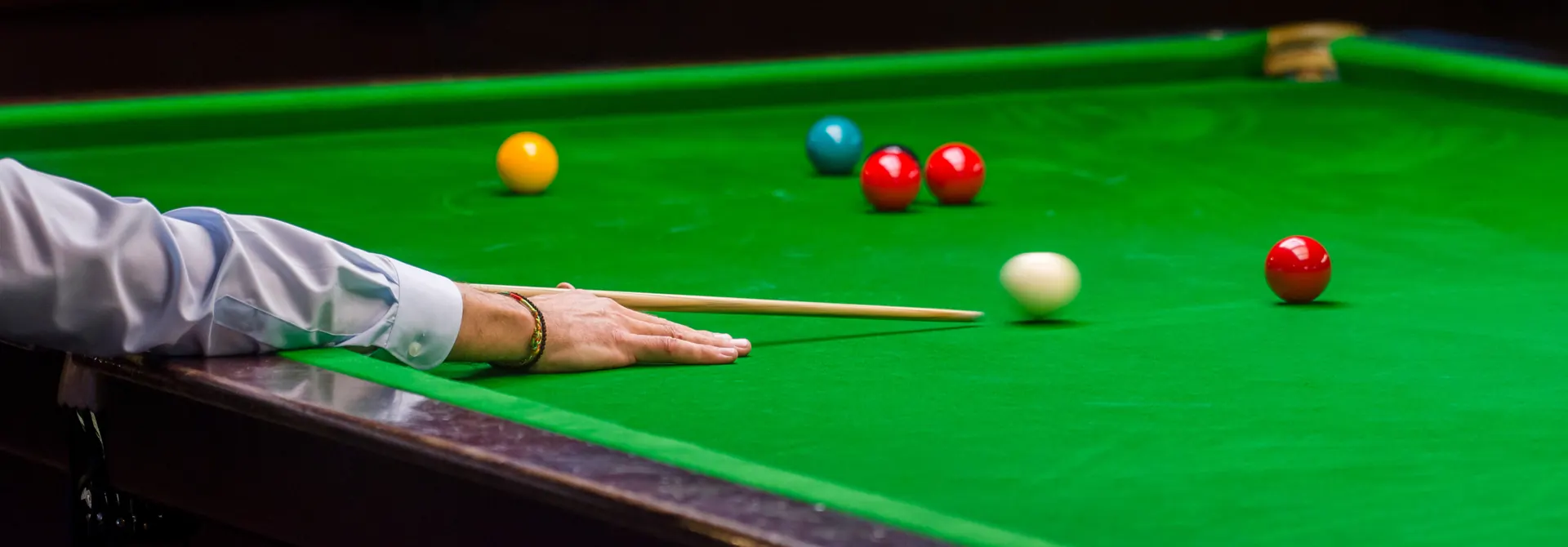 Snookerspieler beim Stoß auf dem grünen Tuch